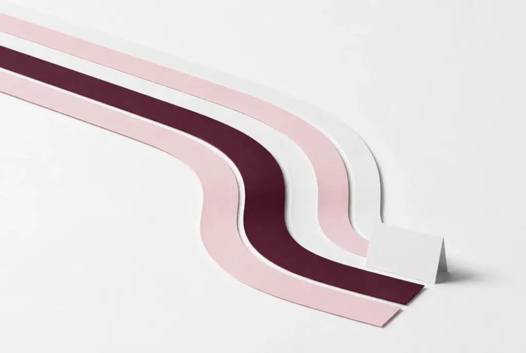 Curved paper strips arranged like running-track lanes in blush and burgundy