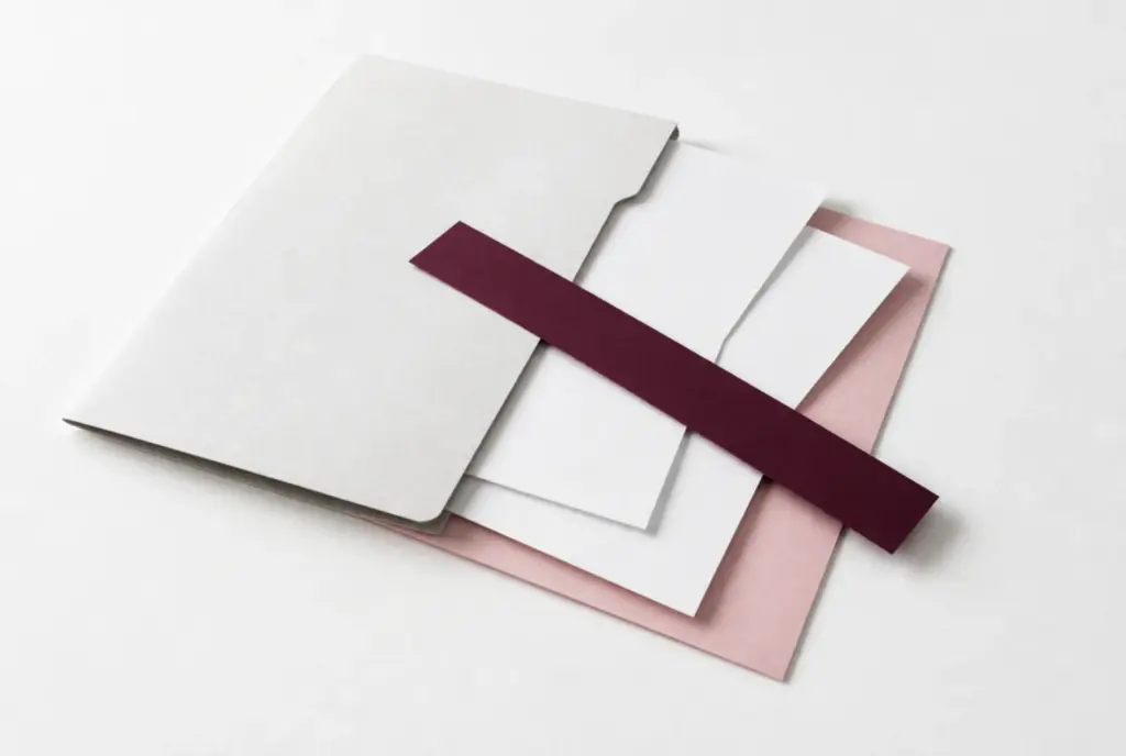 Thin paper folder with loose sheets held by a burgundy paper strip